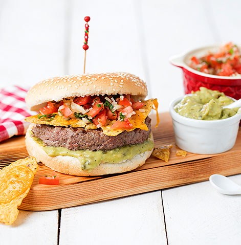 Hambuguer de novilho com guacamole, nachos, queijo cheddar ralado derretido, cebola e tomate picado