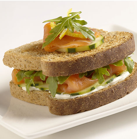 Sanduíche de salmão fumado com queijo fresco para barrar, pepino e rúcula.